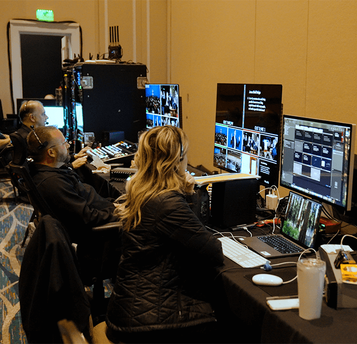 Behind The Scenes - Ligonier National Conference Three Live production specialists sit in a row, watching the live event on individual computer monitors.