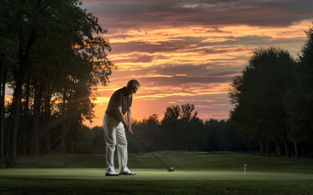 Golfer teeing off at sunrise during behind-the-scenes shoot for Coates Golf commercial