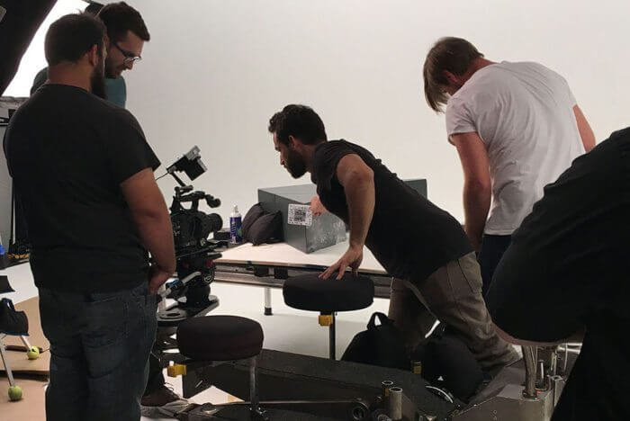Skystorm crew preparing camera setup during studio production Behind the scenes of a commercial shoot with Skystorm Productions' crew setting up a camera on a studio set