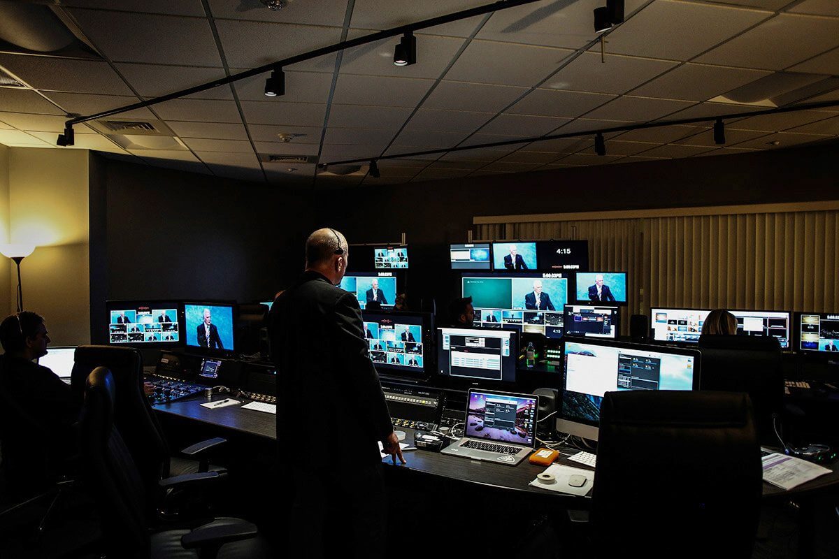 Director and crew working in a live broadcast control room surrounded by multiview monitors