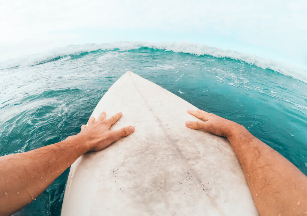 Young man having fun surfing on high waves ocean - Sporty surfer first person POV of a surfer